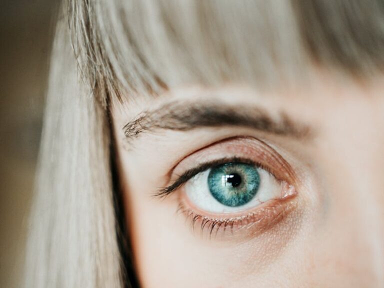 A macro shot of a blue human eye highlighting the detailed iris and eyelashes.